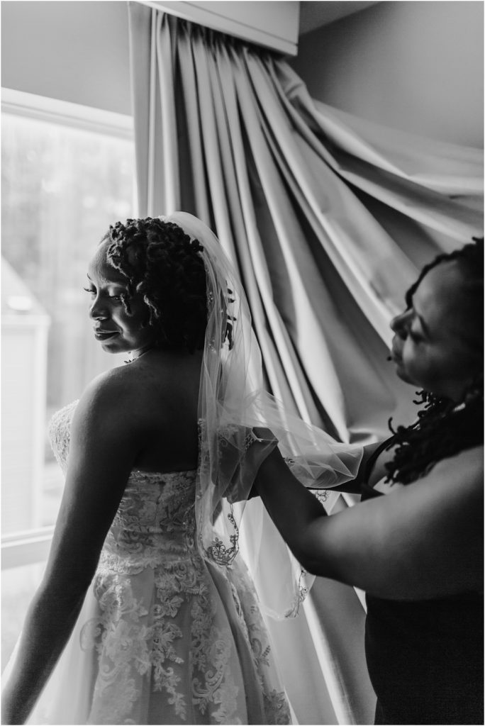 Mother helping bride into dress photo